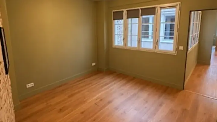 Pièce principale après peinture : murs vert olive et parquet en chêne