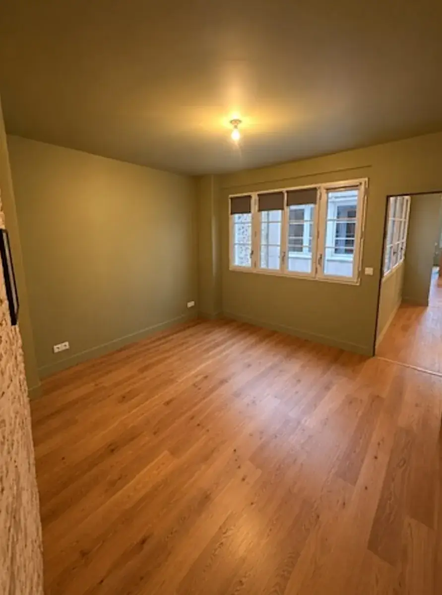 Pièce principale après peinture : murs vert olive et parquet en chêne