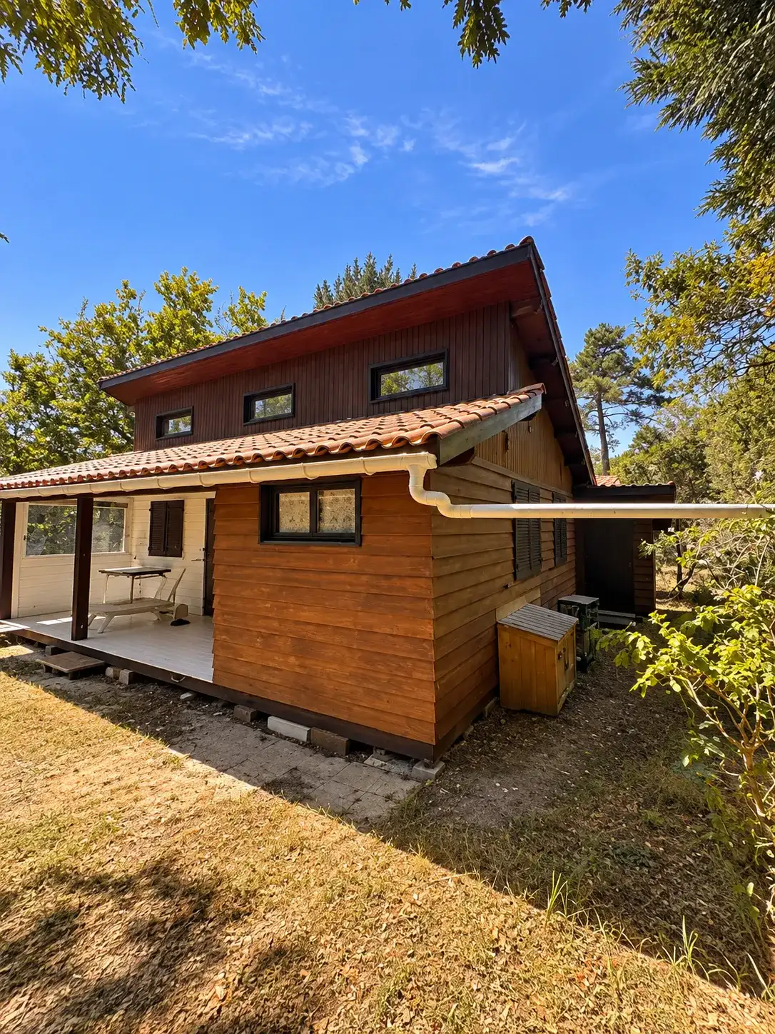 Avant les travaux, la façade latérale en bois teinté orangé