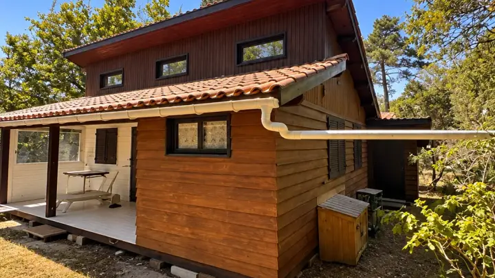 Avant les travaux, la façade latérale en bois teinté orangé
