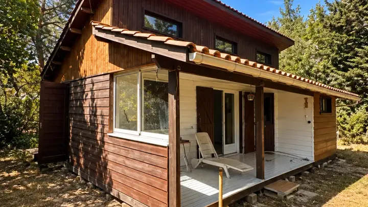 Pignon et terrasse couverte avant peinture : bardage en bois brun foncé