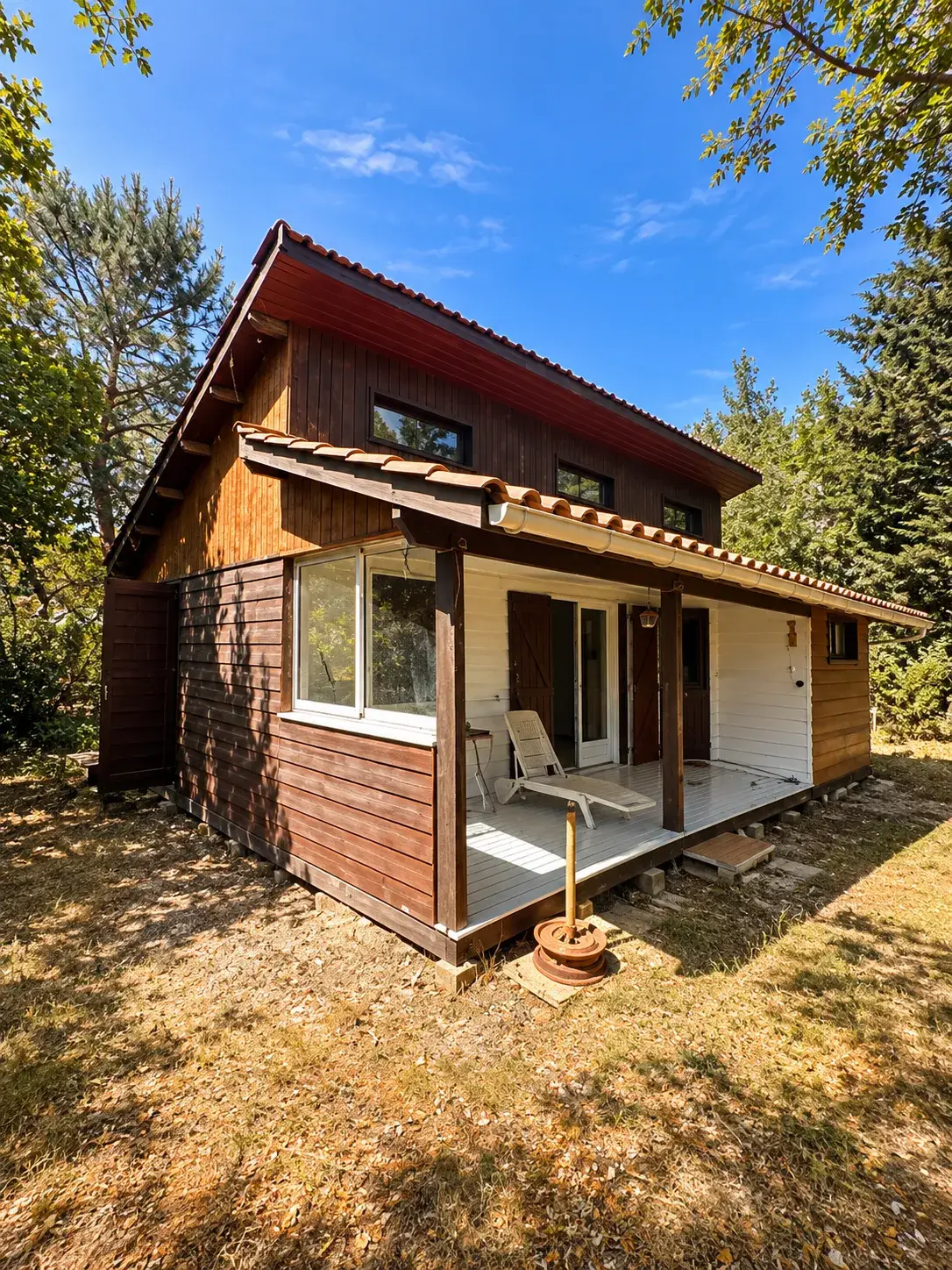 Pignon et terrasse couverte avant peinture : bardage en bois brun foncé